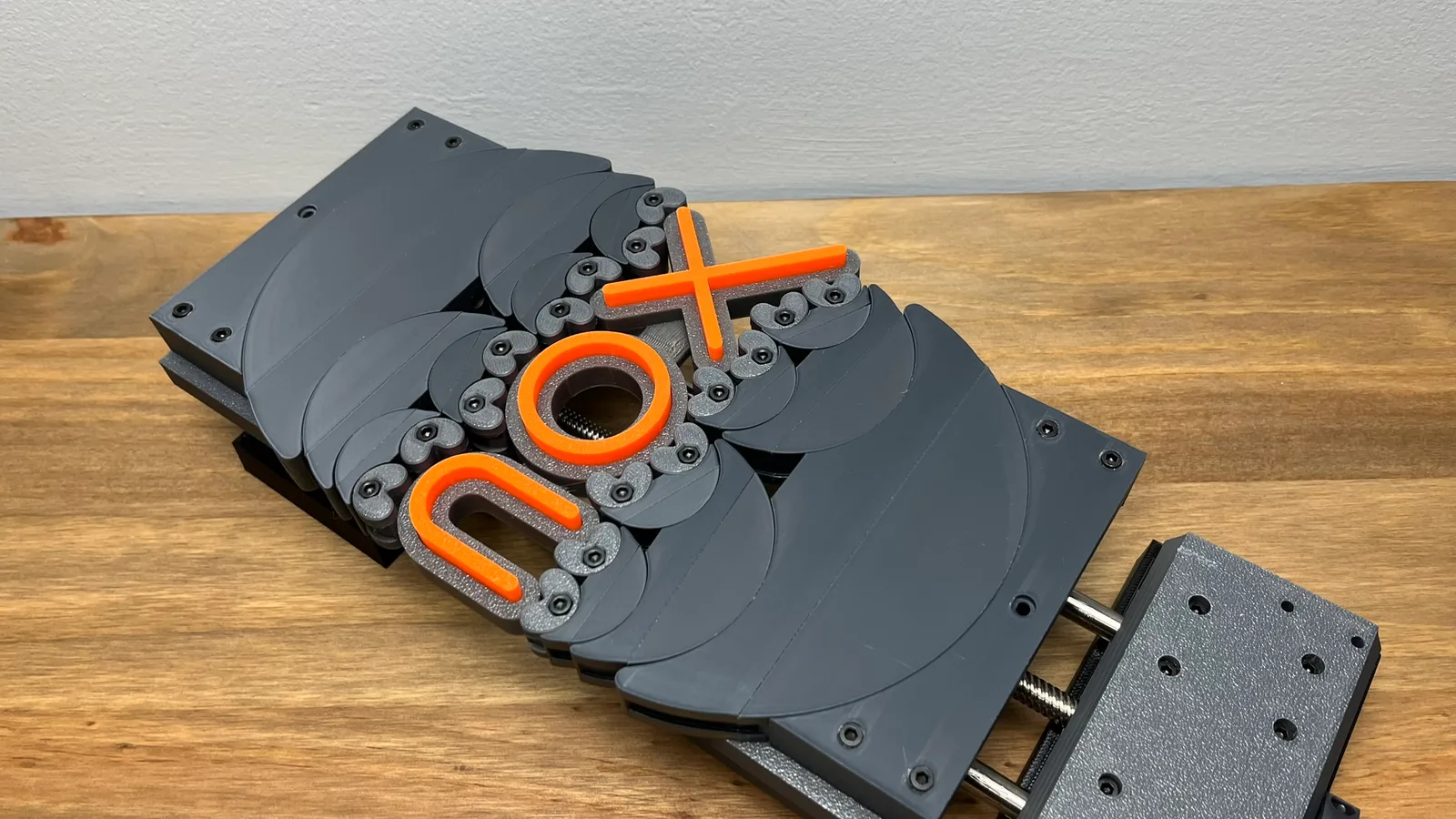 Nox-branded 3D printed compliant flexure mechanism in grey and orange, printed in-house by Nox 3D Printing Services in Raleigh NC