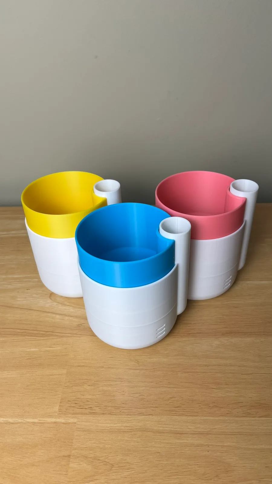 Modular 3D printed cups in white, yellow, blue, and pink PETG printed by Nox Print